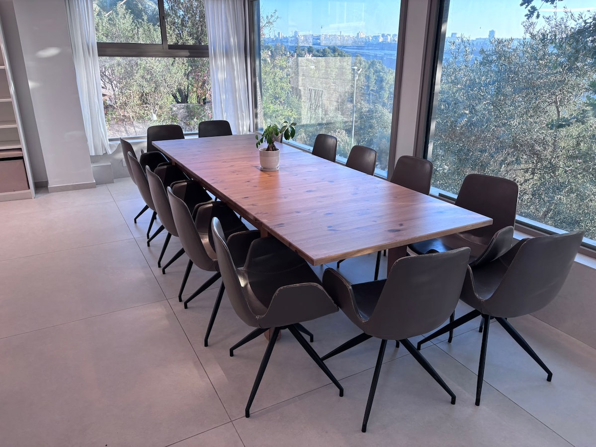 Sunlit dining room overlooking Jerusalem's wooded hills