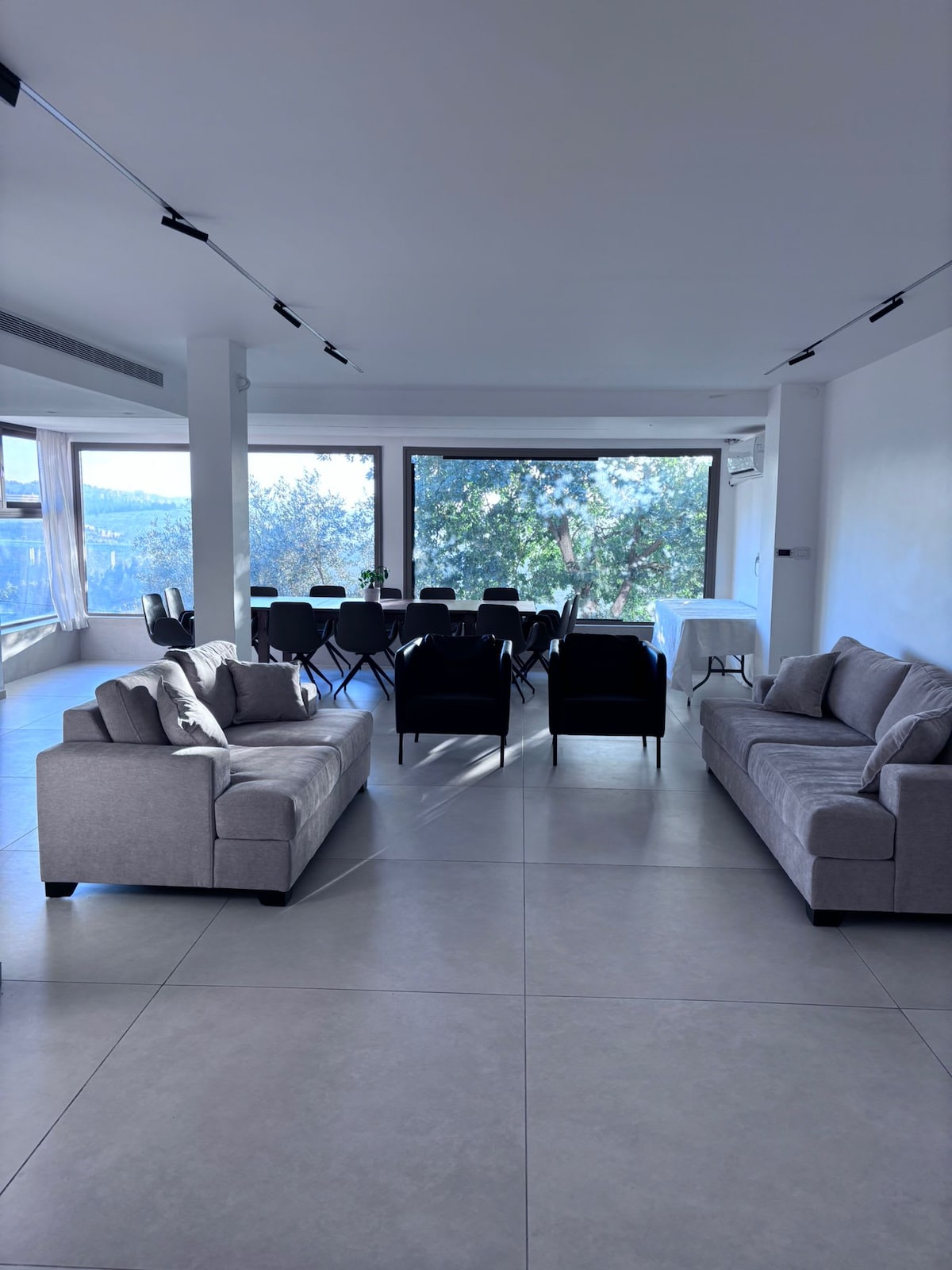Expansive living room with full-height forest views